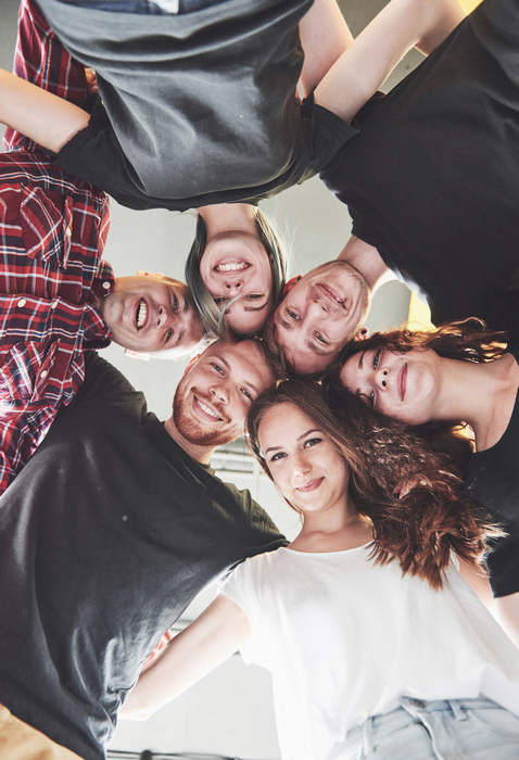 smiling students stand in a circle and hold hands